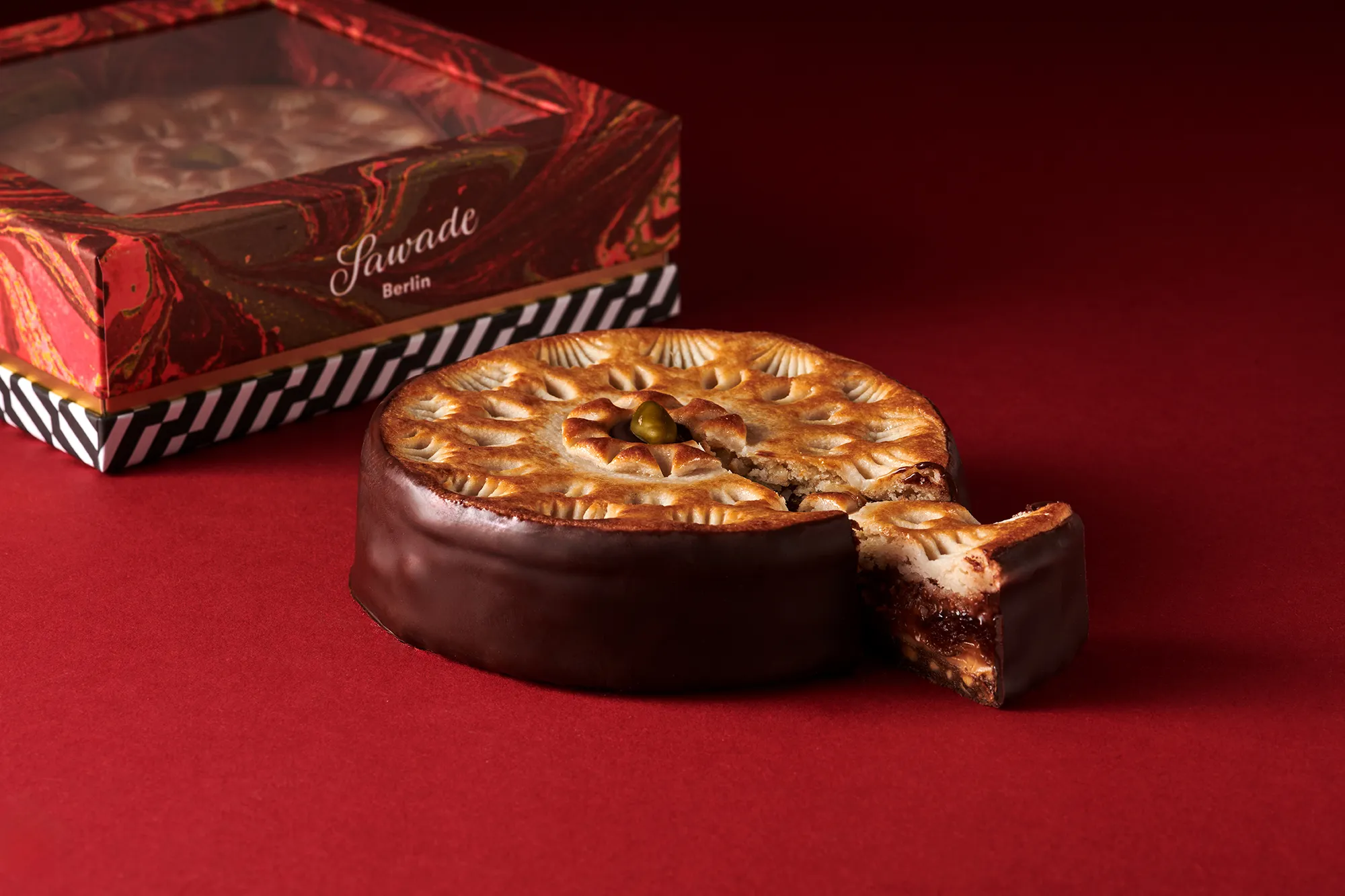 Die Sawade Torte in Geschenkschachtel Sawade Torte angeschnitten mit Geschenkverpackung im Hintergrund